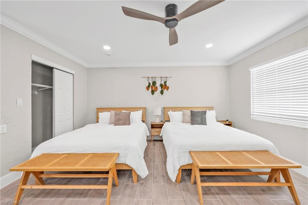 Bedroom with wood finish floors, crown molding, a closet, a ceiling fan, and recessed lighting
