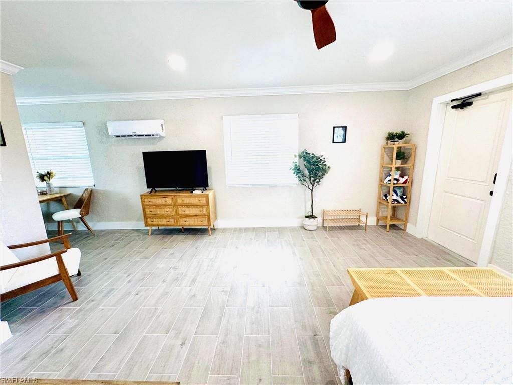 Bedroom featuring wood tiled floors, crown molding, ceiling fan, and recessed lighting