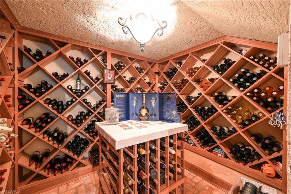 Wine area with brick floors and a textured ceiling