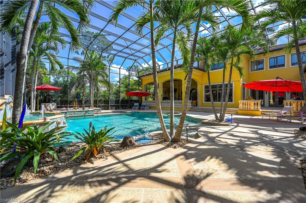 Swimming pool featuring a patio, glass enclosure, and a hot tub