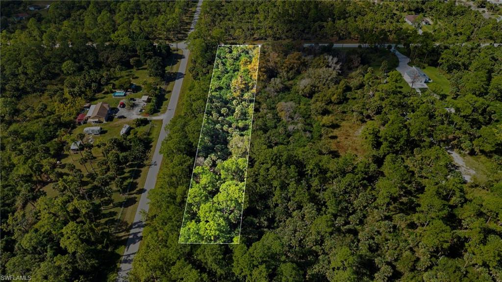 Aerial overview of property's location featuring property boundaries highlighted and a heavily wooded area