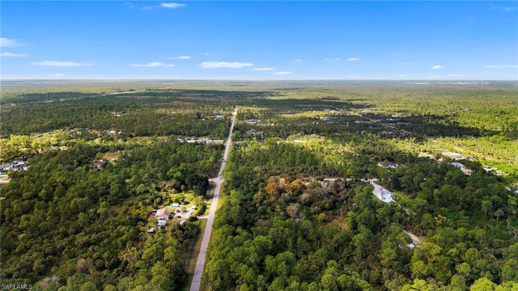 Aerial view of property and surrounding area featuring a forest