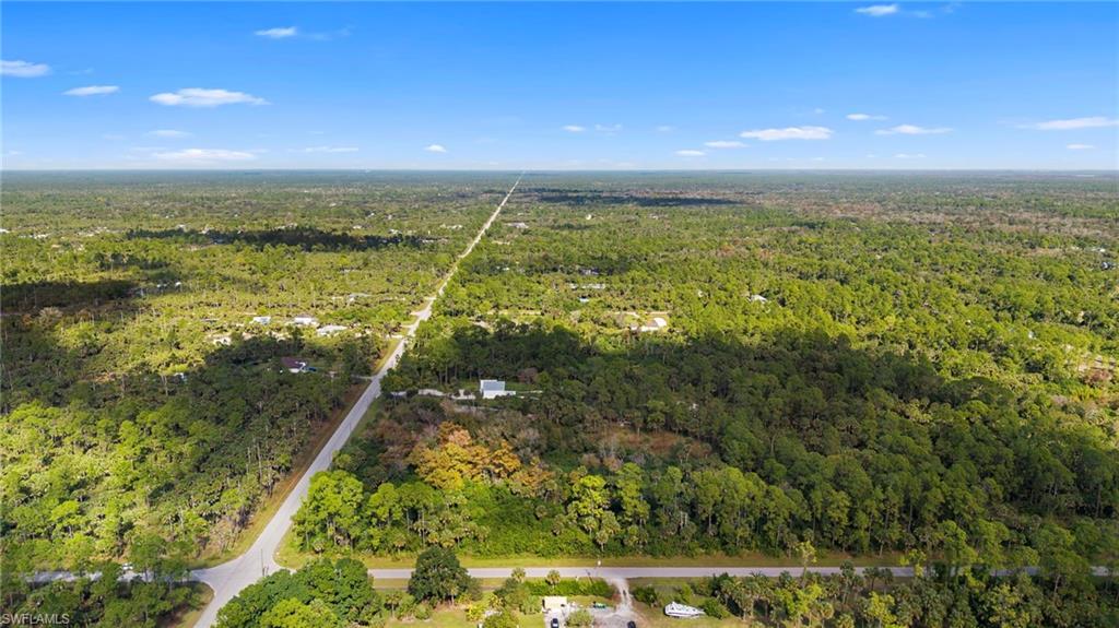 Aerial view of property and surrounding area featuring a heavily wooded area