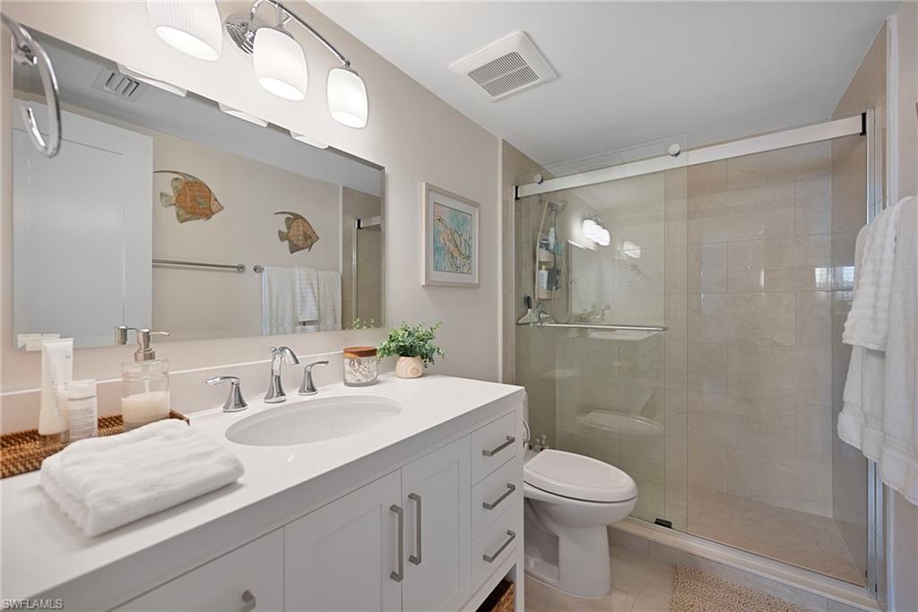 Bathroom featuring vanity, a stall shower, and light tile patterned floors