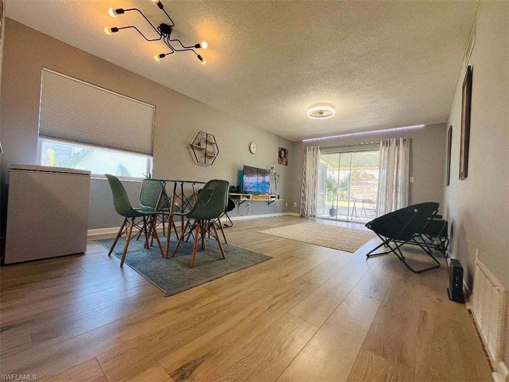 Dining room with a textured ceiling and light wood-type flooring