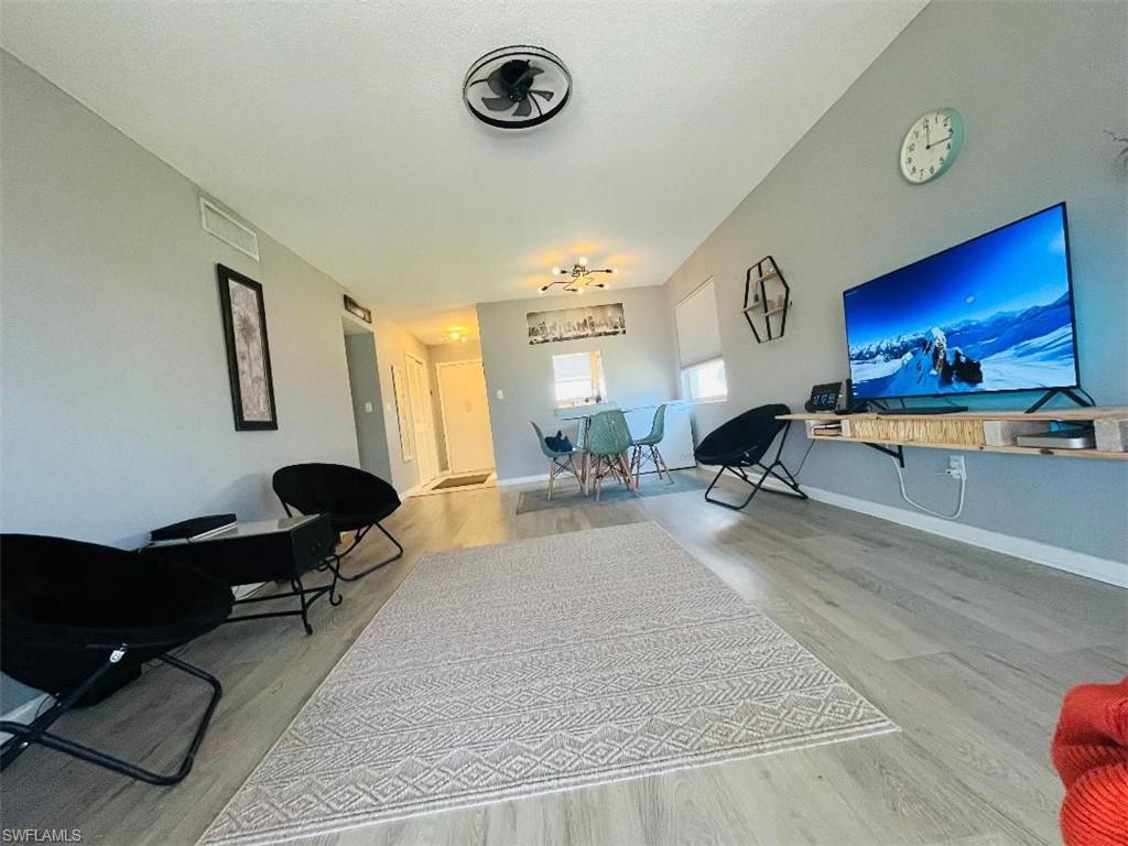 Living area featuring light wood-type flooring and baseboards