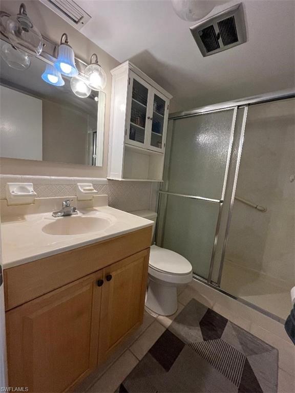 Bathroom with vanity, a shower stall, and light tile patterned flooring