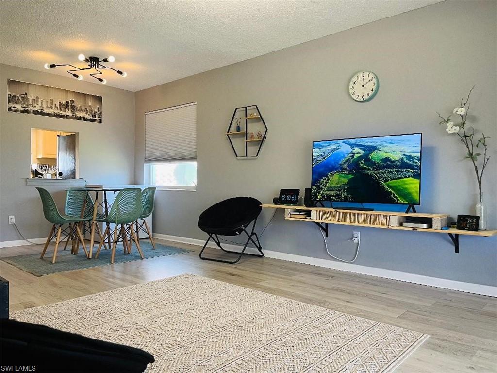 Living room featuring light wood-type flooring and a textured ceiling