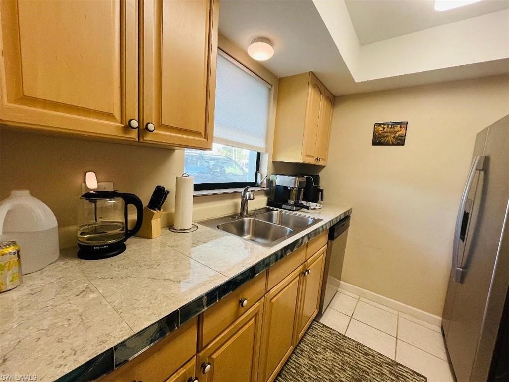 Kitchen featuring stainless steel appliances, light tile patterned flooring, and tile counters