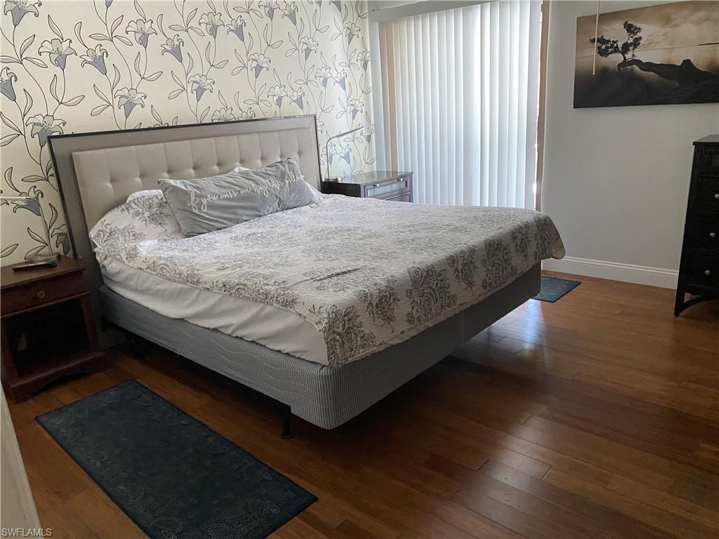 Bedroom featuring baseboards and dark wood-style flooring