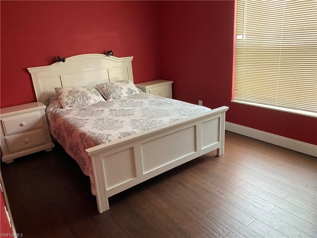 Bedroom featuring baseboards and dark wood-style floors