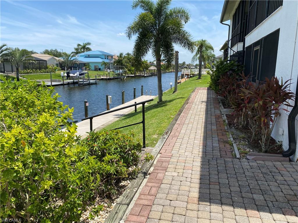 View of community with a water view, a yard, a dock, and a residential view