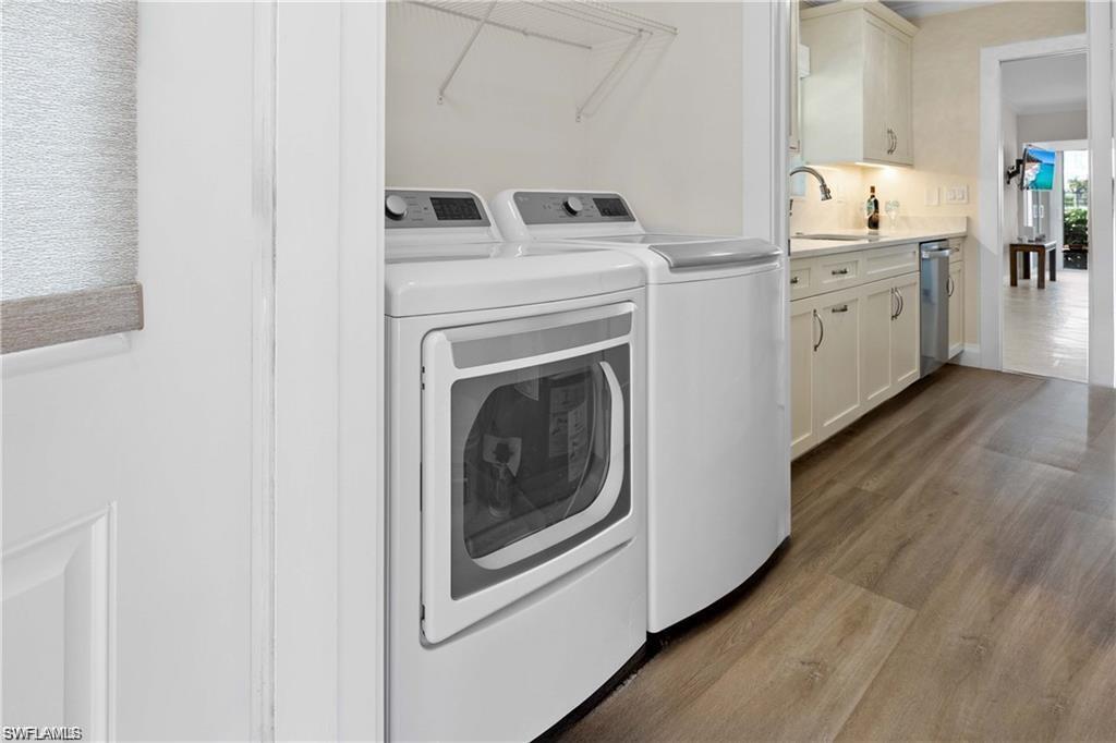 Washroom with dark wood finished floors and separate washer and dryer