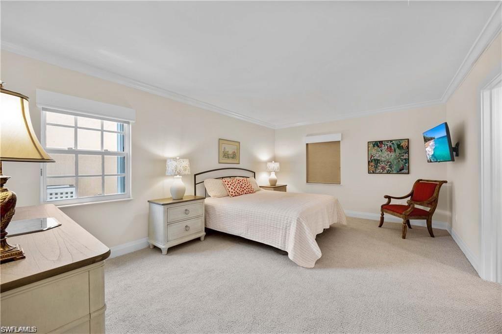 Bedroom featuring light colored carpet and ornamental molding