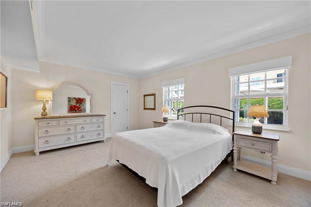 Bedroom featuring light colored carpet and crown molding