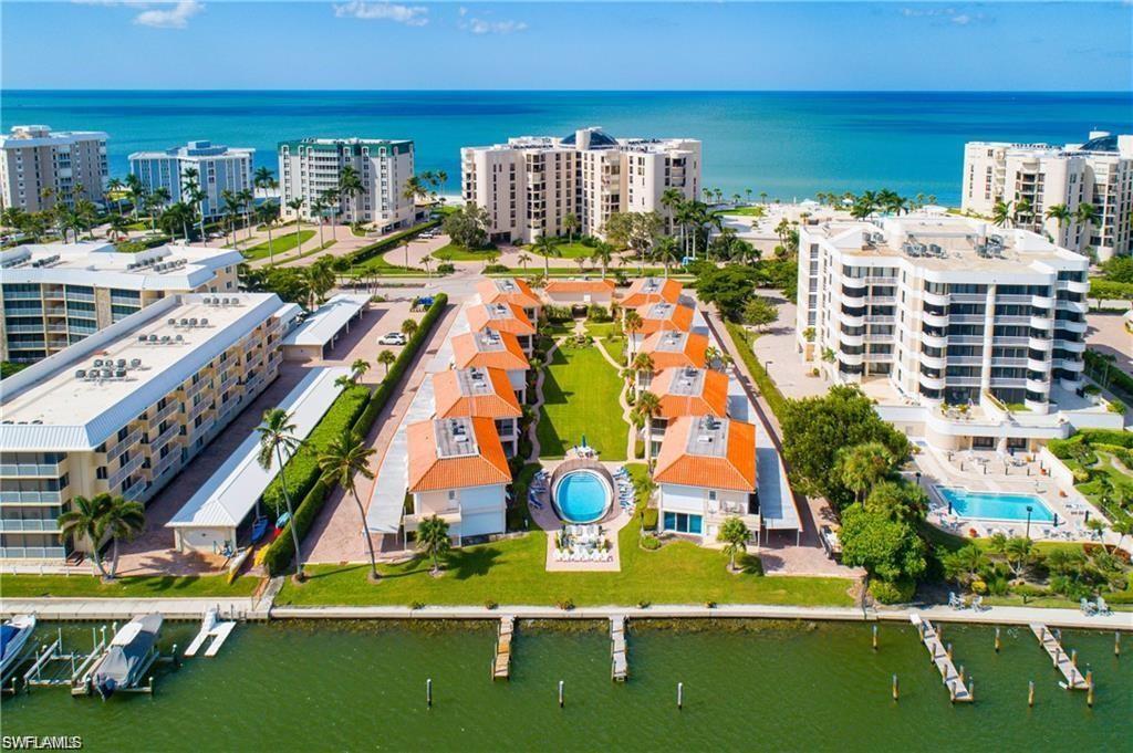 Drone / aerial view of a nearby body of water and a pool area