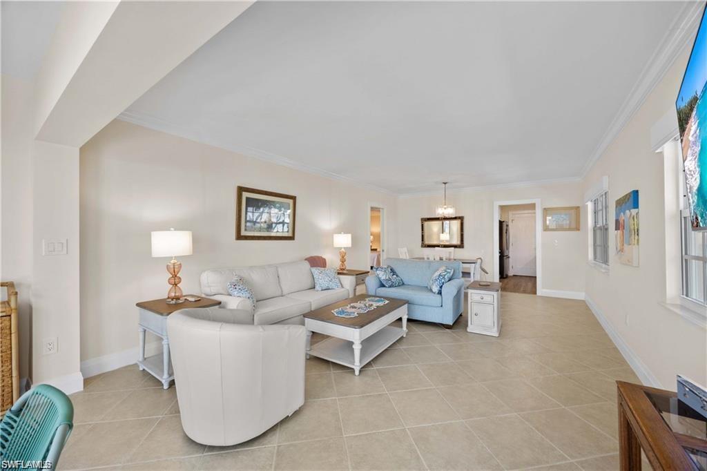 Living area featuring light tile patterned flooring and ornamental molding