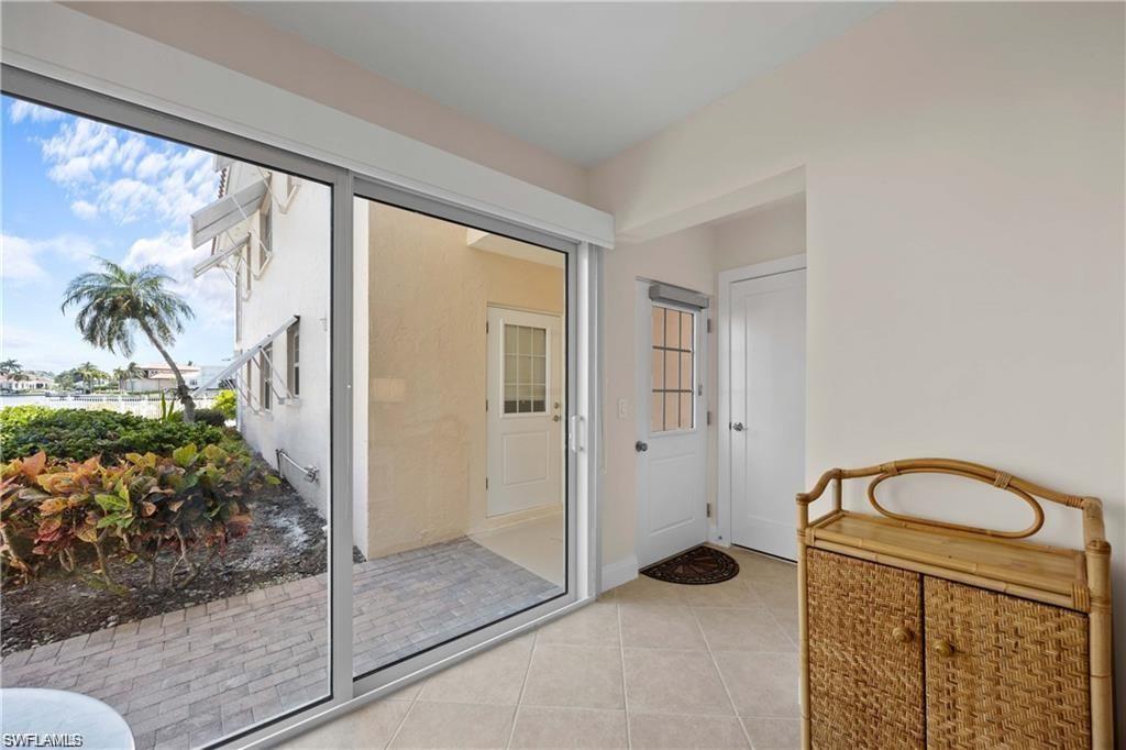 Doorway with tile patterned flooring and baseboards