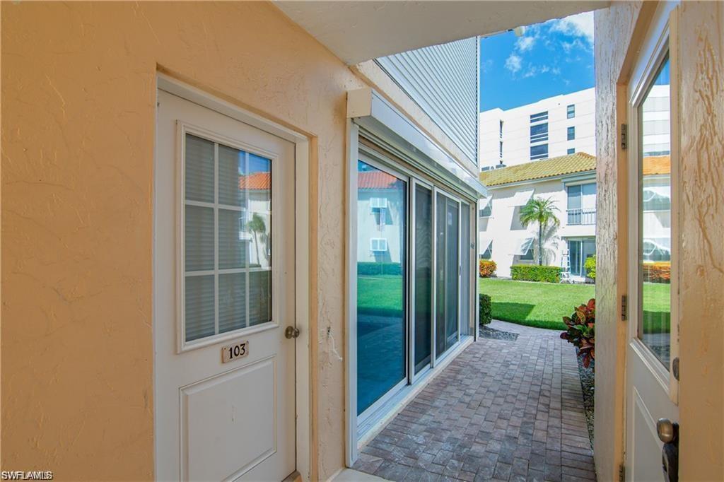 Doorway to outside with a textured wall, healthy amount of natural light, and brick flooring