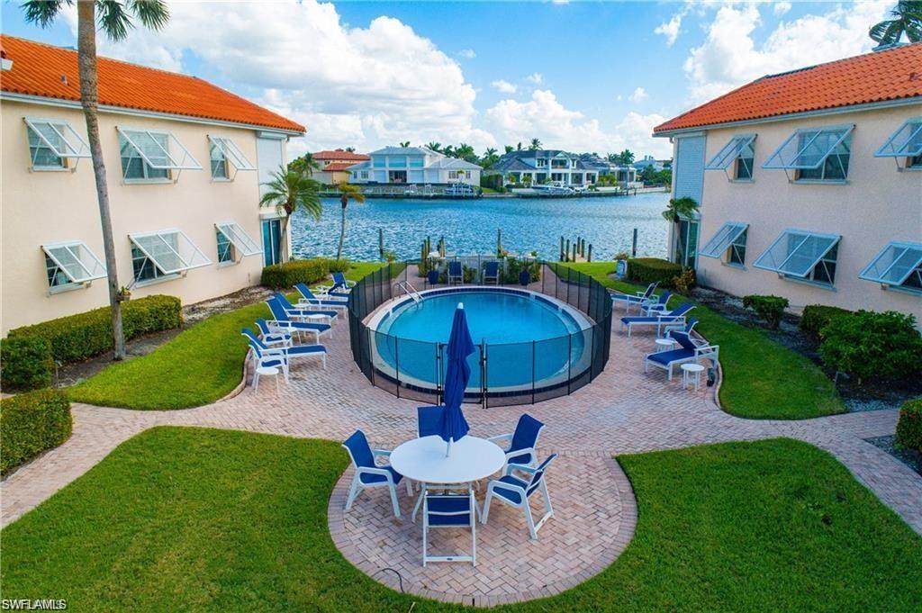 Community pool with a patio, a water view, and a lawn