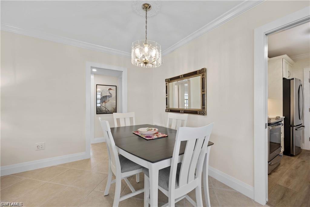 Dining room featuring crown molding, light tile patterned floors, and a chandelier