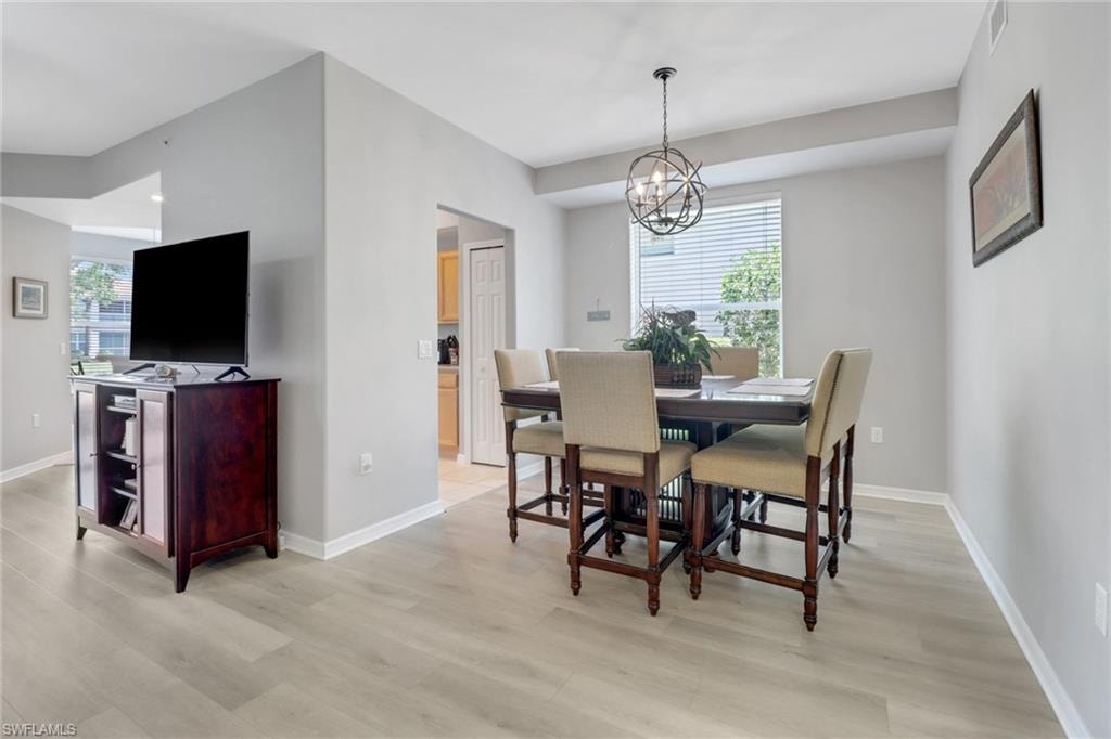 Dining area featuring plenty of natural light, light wood-style floors, and a chandelier