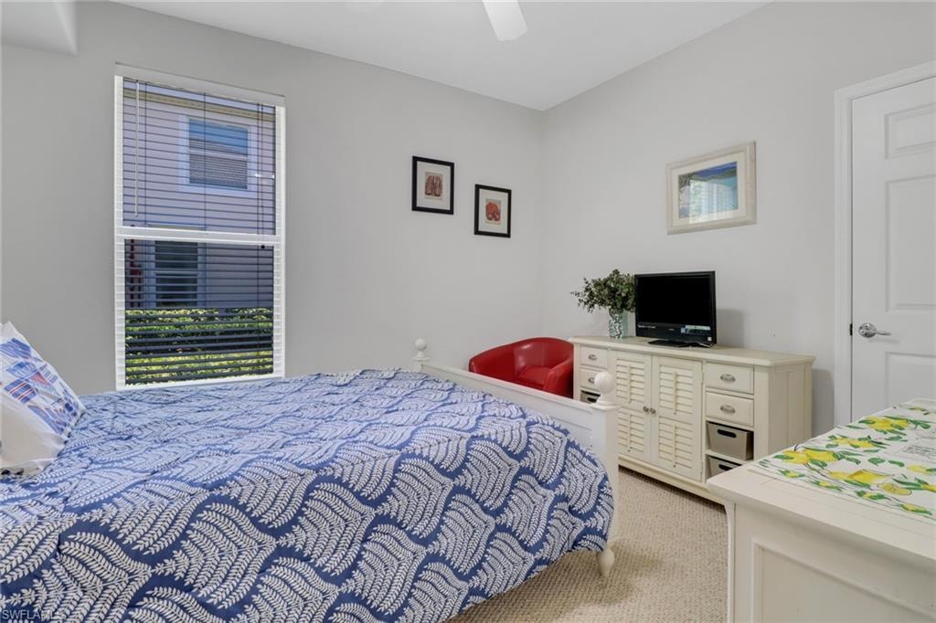 Bedroom featuring light colored carpet, ceiling fan, and multiple windows
