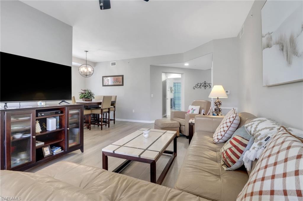 Living area featuring light wood finished floors and a chandelier