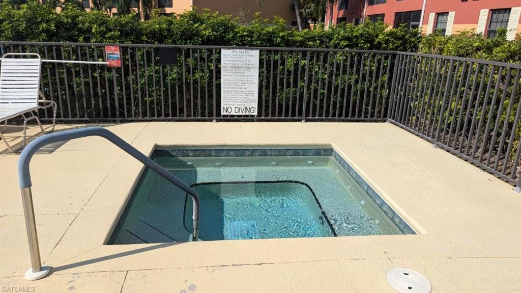 View of swimming pool featuring a community hot tub
