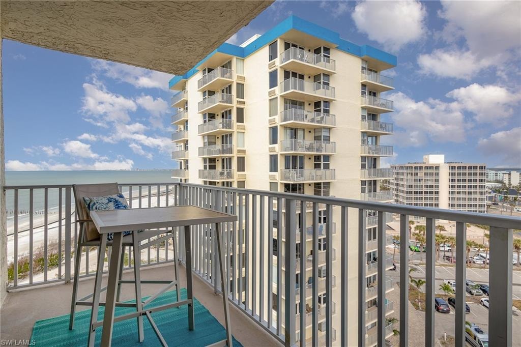 Balcony featuring view of water and beach