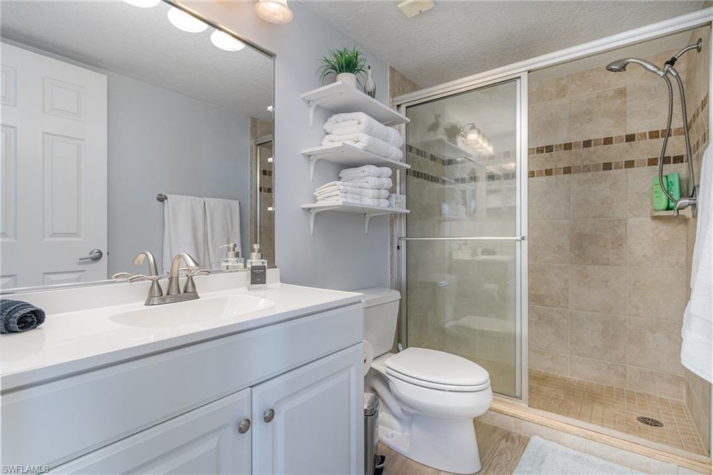 Full bathroom with vanity, a textured ceiling, and walk-in shower