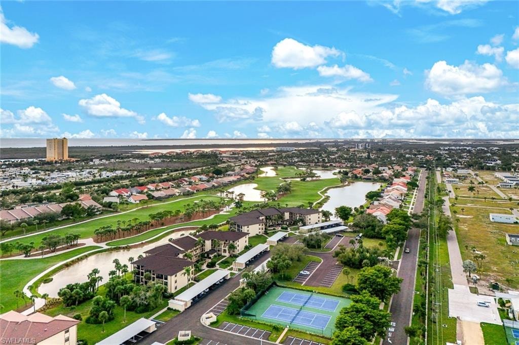 Aerial view of residential area featuring a nearby body of water and a golf club