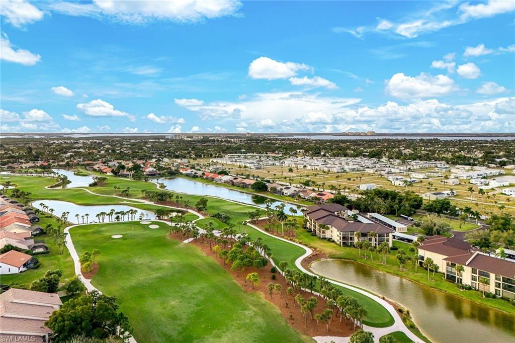 Aerial view of residential area featuring a nearby body of water and a golf course