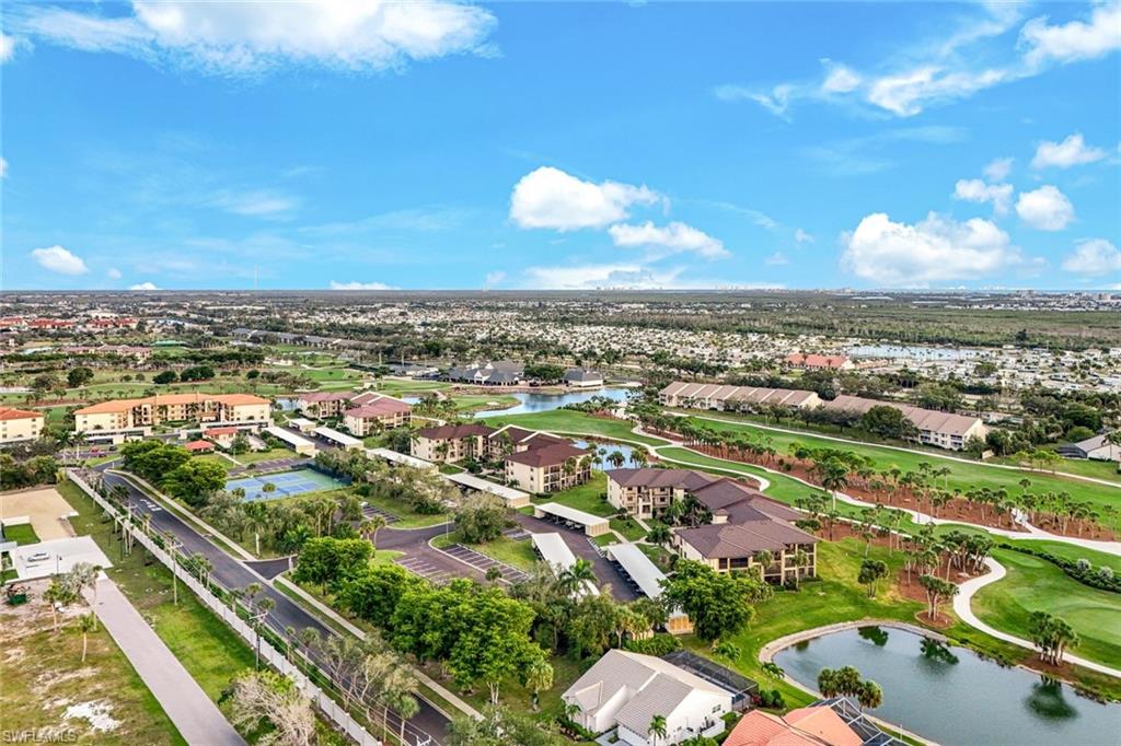 Aerial view of residential area featuring a nearby body of water and a golf course