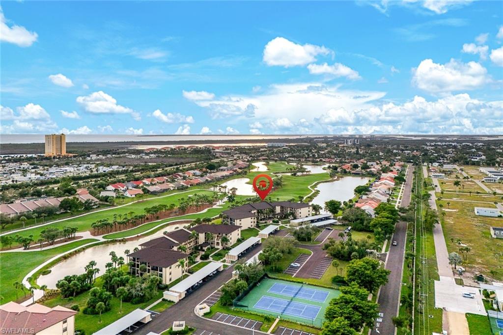 Aerial perspective of suburban area featuring a nearby body of water and a golf club