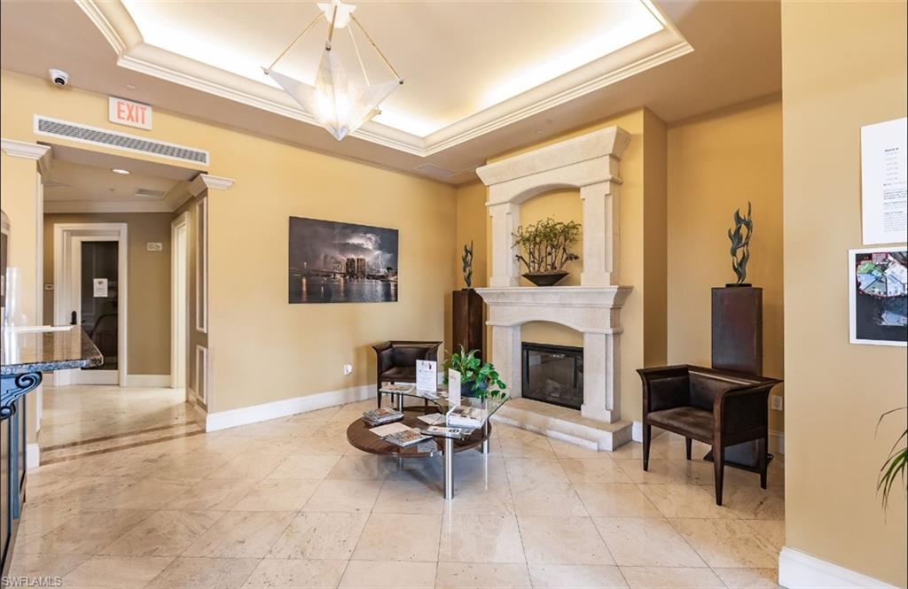 Living area featuring crown molding, a tray ceiling, a ceiling fan, built in features, and recessed lighting