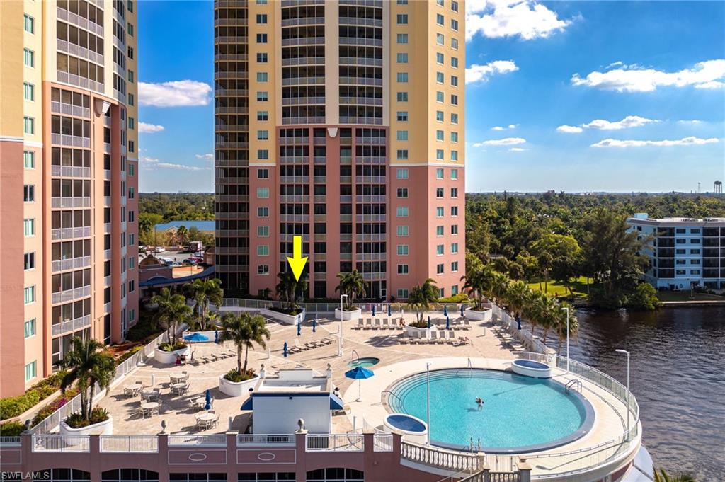 Community pool featuring a water view, area for grilling, and a patio area