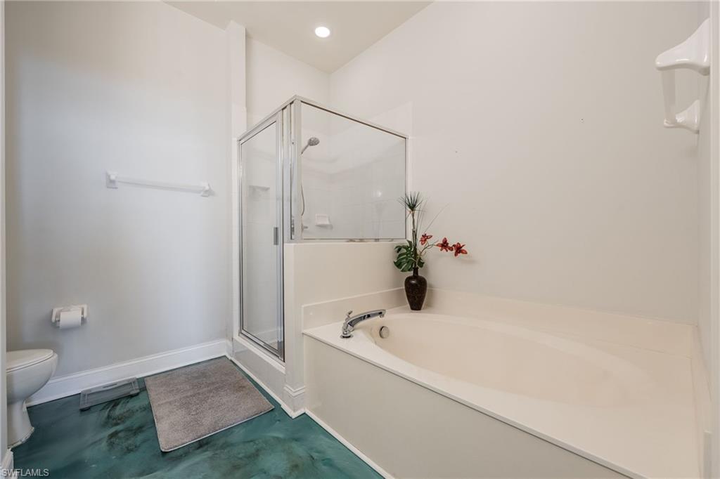 Master bath featuring a shower stall and a garden tub