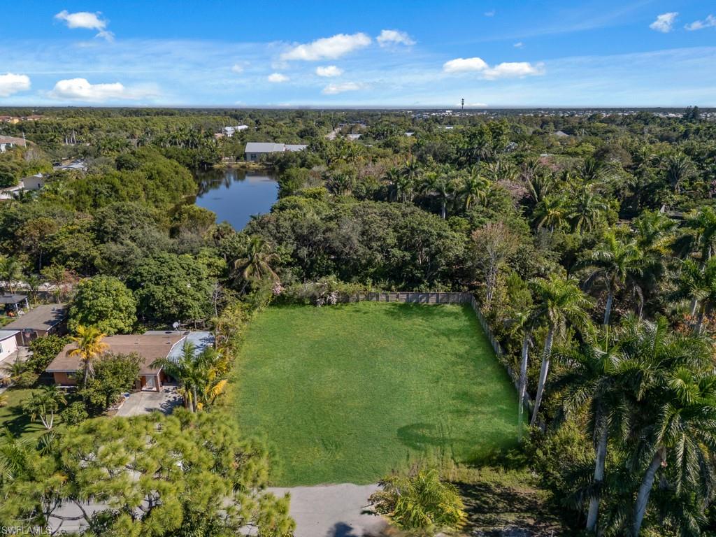 Aerial overview of property's location with a nearby body of water and a forest