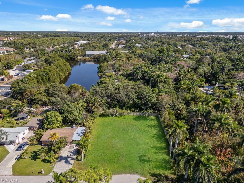 View of property location with a large body of water and a heavily wooded area