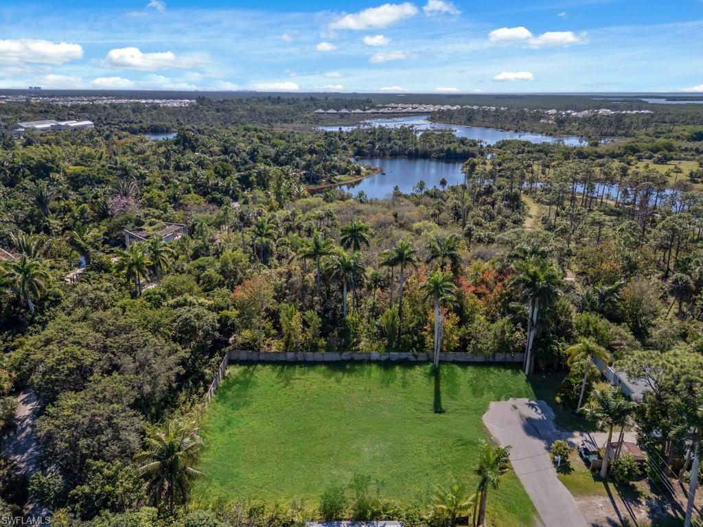 Aerial view of property's location featuring a forest and a nearby body of water