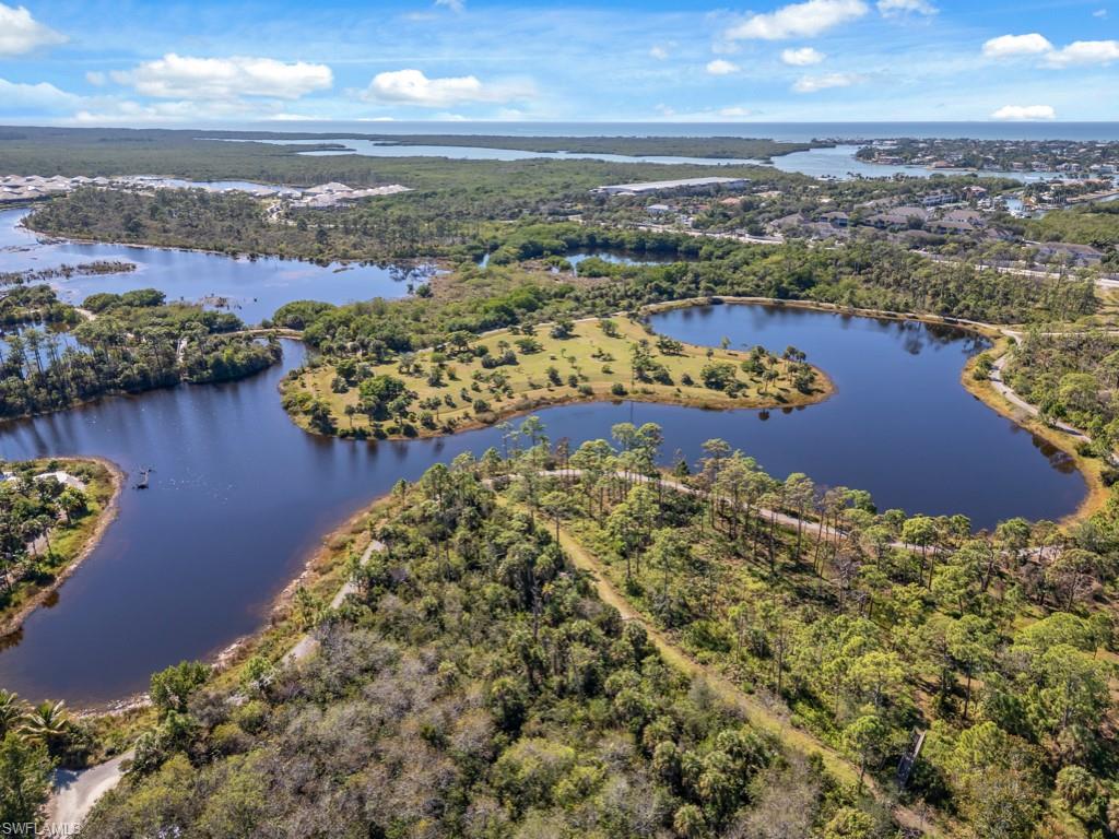 Drone / aerial view of a nearby body of water and a heavily wooded area