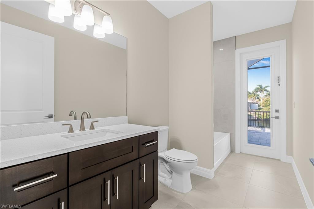 Bathroom featuring vanity, light tile patterned floors, and shower / washtub combination
