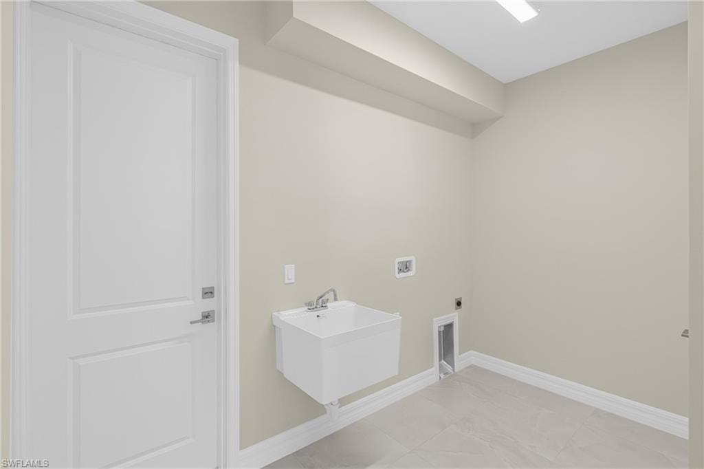 Laundry area featuring hookup for a washing machine, hookup for an electric dryer, and light tile patterned flooring