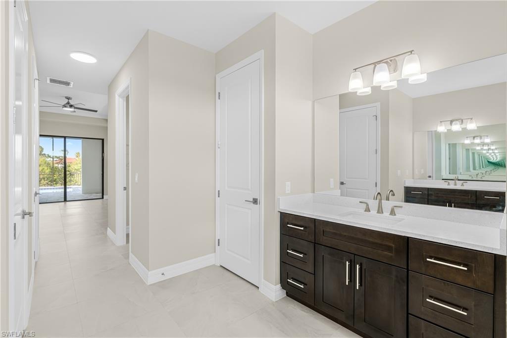 Full bath with vanity, ceiling fan, and light tile patterned floors