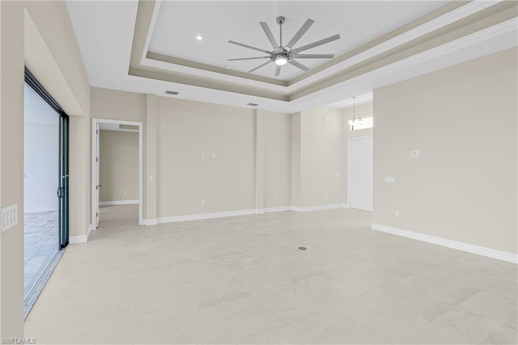 Unfurnished bedroom with a tray ceiling and a ceiling fan