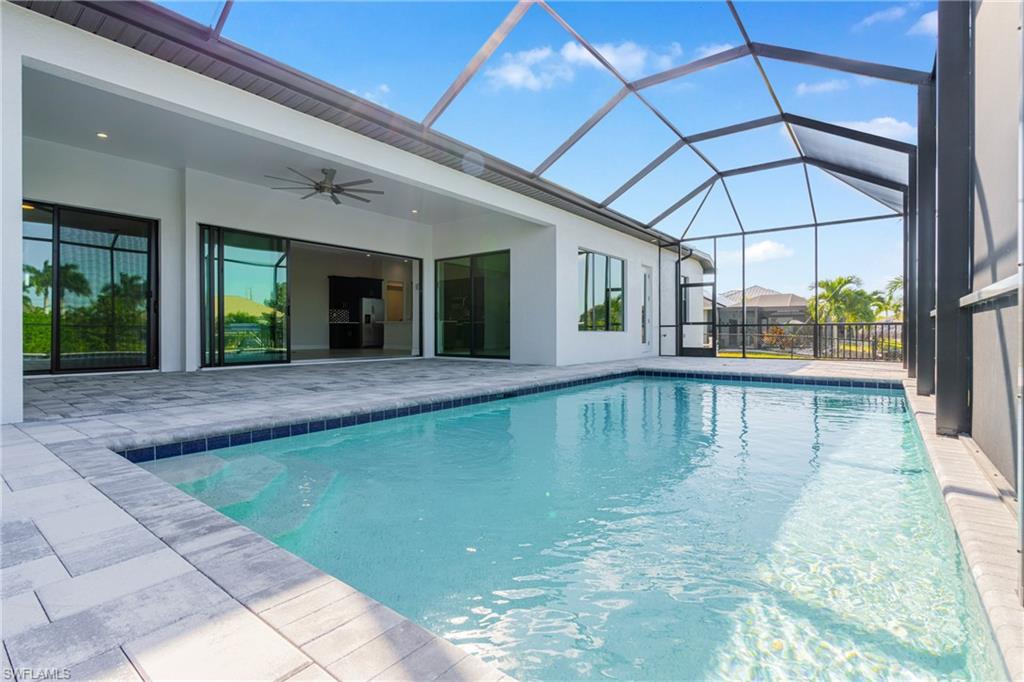 Swimming pool featuring a ceiling fan, a lanai, a sunroom, and a patio