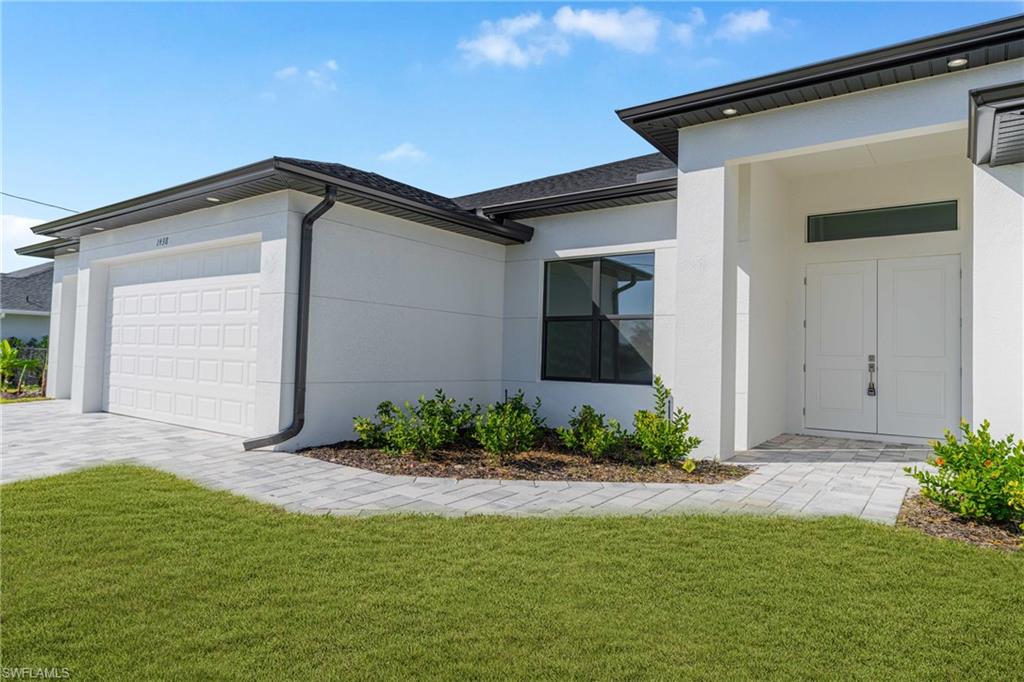 View of property exterior with a yard, an attached garage, and stucco siding