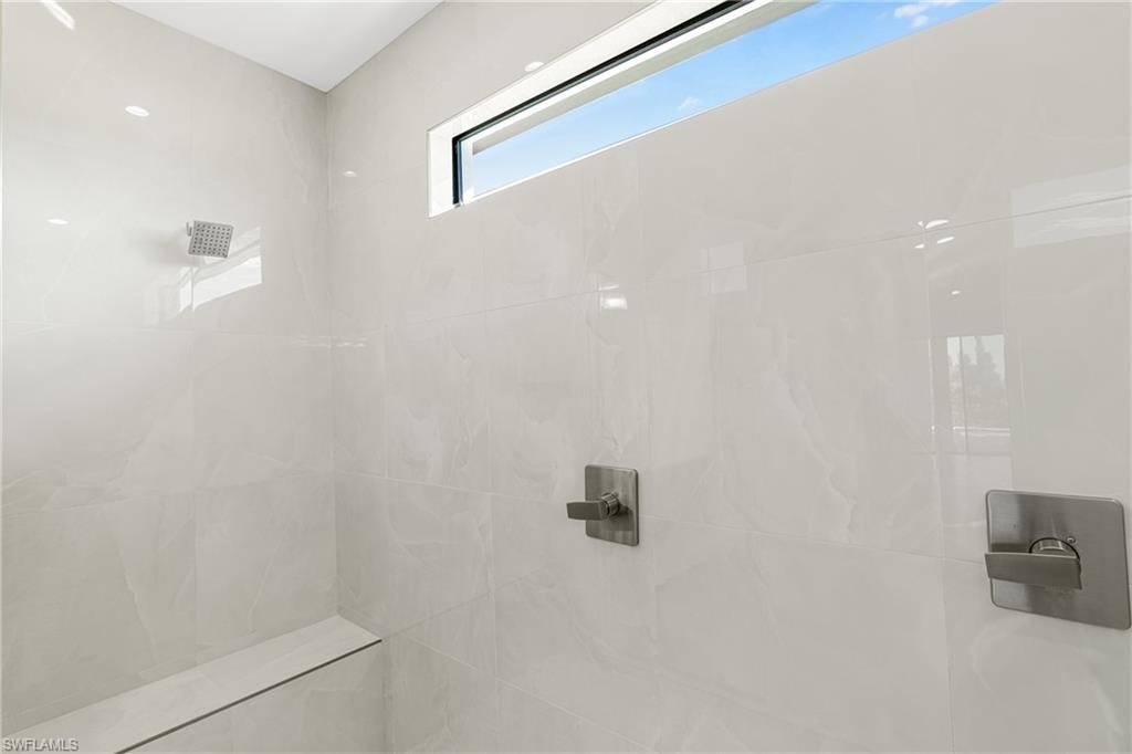 Full bath featuring tiled shower