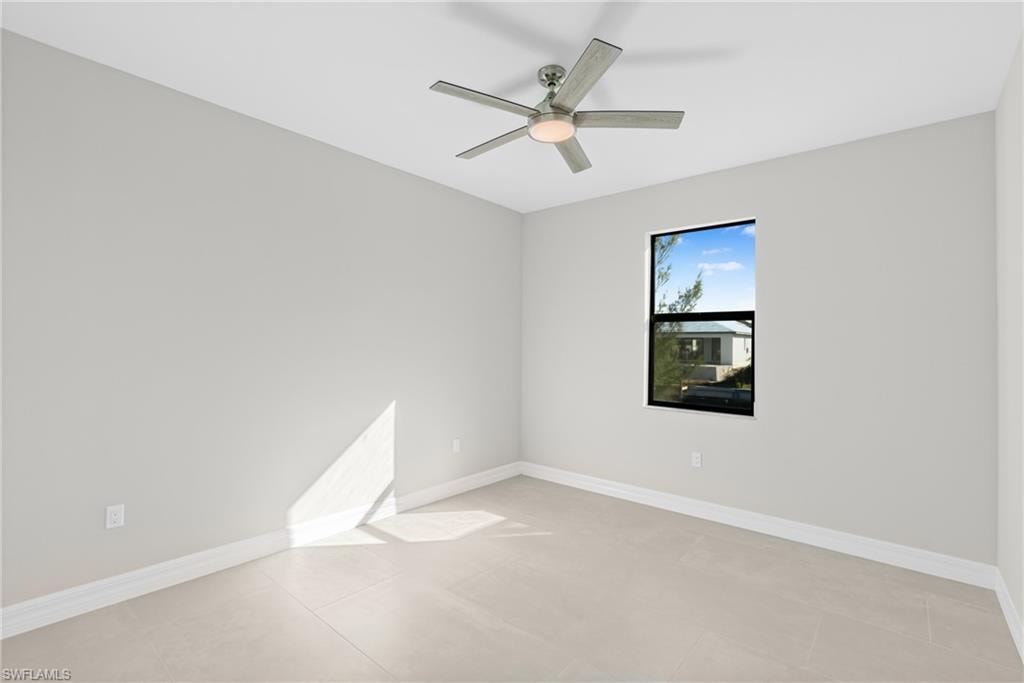 Spare room with ceiling fan and light tile patterned floors